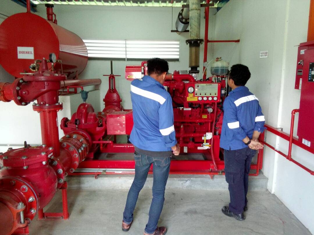 Deqara technicians inspecting a diesel fire pump engine on site