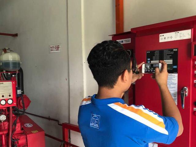 Technician checking a fire pump controller panel