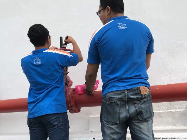Technicians inspecting exposed fire main pipework