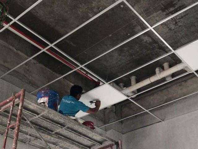 Technician working at ceiling level on a fire protection installation