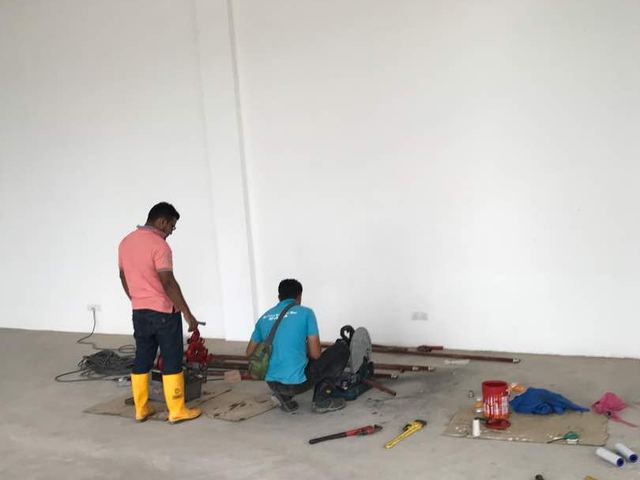 Technicians working on pipework at a new building site
