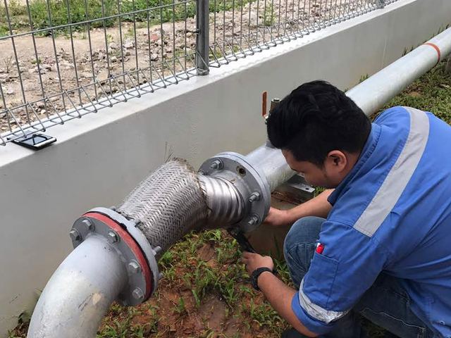Technician fitting a flexible joint on an outdoor fire main