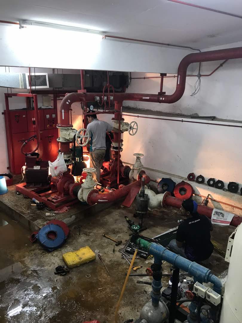 Technicians servicing sprinkler system piping on an industrial site