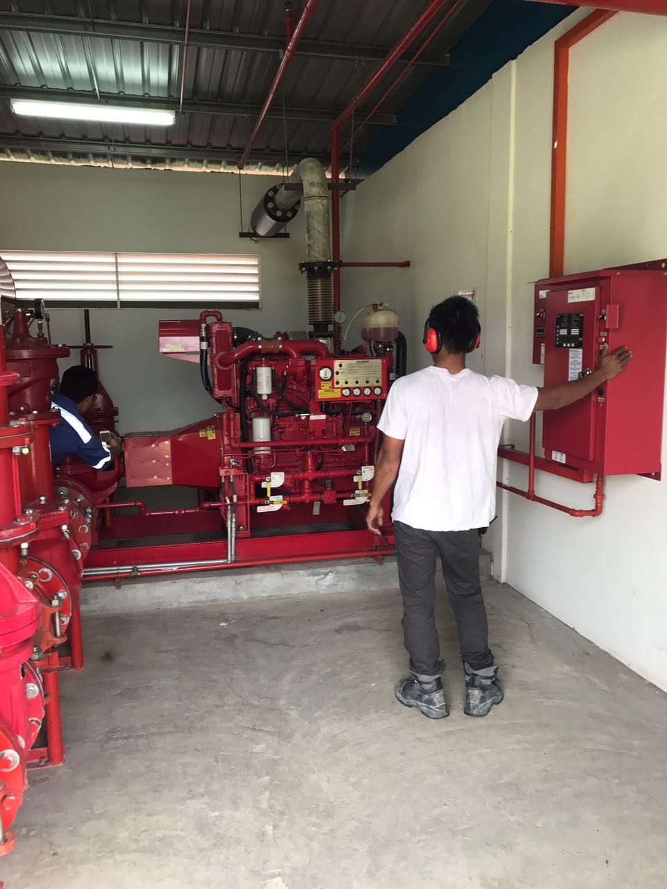 Technician operating a fire pump control panel